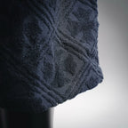 Close-up of textured dark navy shorts fabric with raised pattern