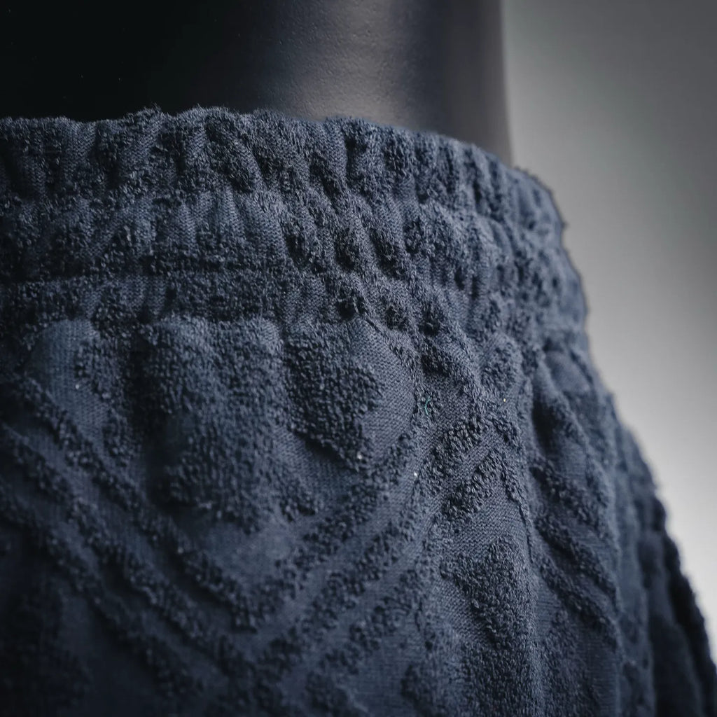Close-up of dark navy shorts waistband and textured front pattern