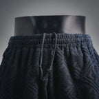 Front view of dark navy elastic-waist shorts with pleated drape