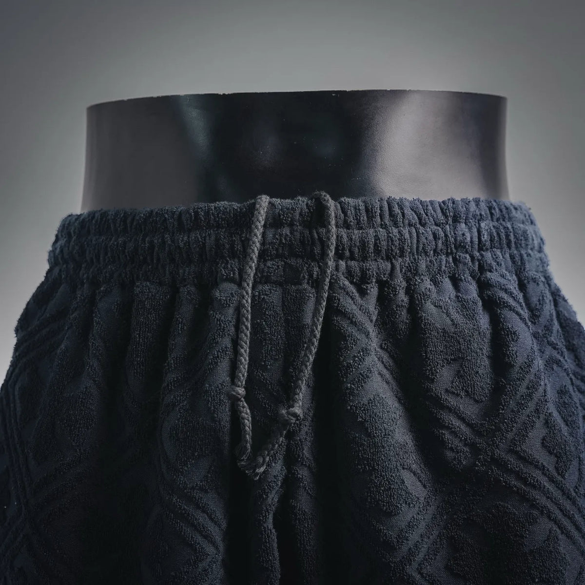 Front view of dark navy elastic-waist shorts with pleated drape