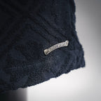 Side hem of dark navy textured shorts with small silver label