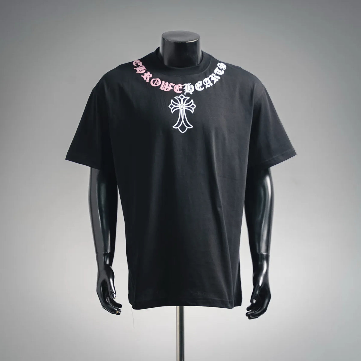 Black short-sleeve T-shirt with front graphic emblem and pink/white lettering