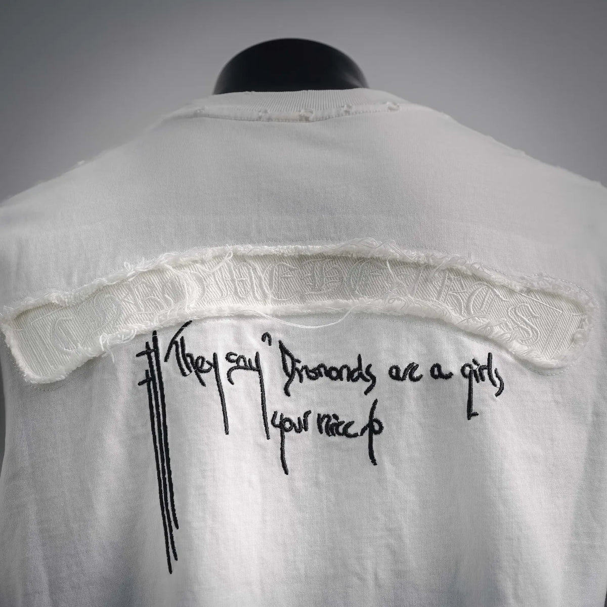 Close-up of T-shirt back graphic text with cross accents under distressed print