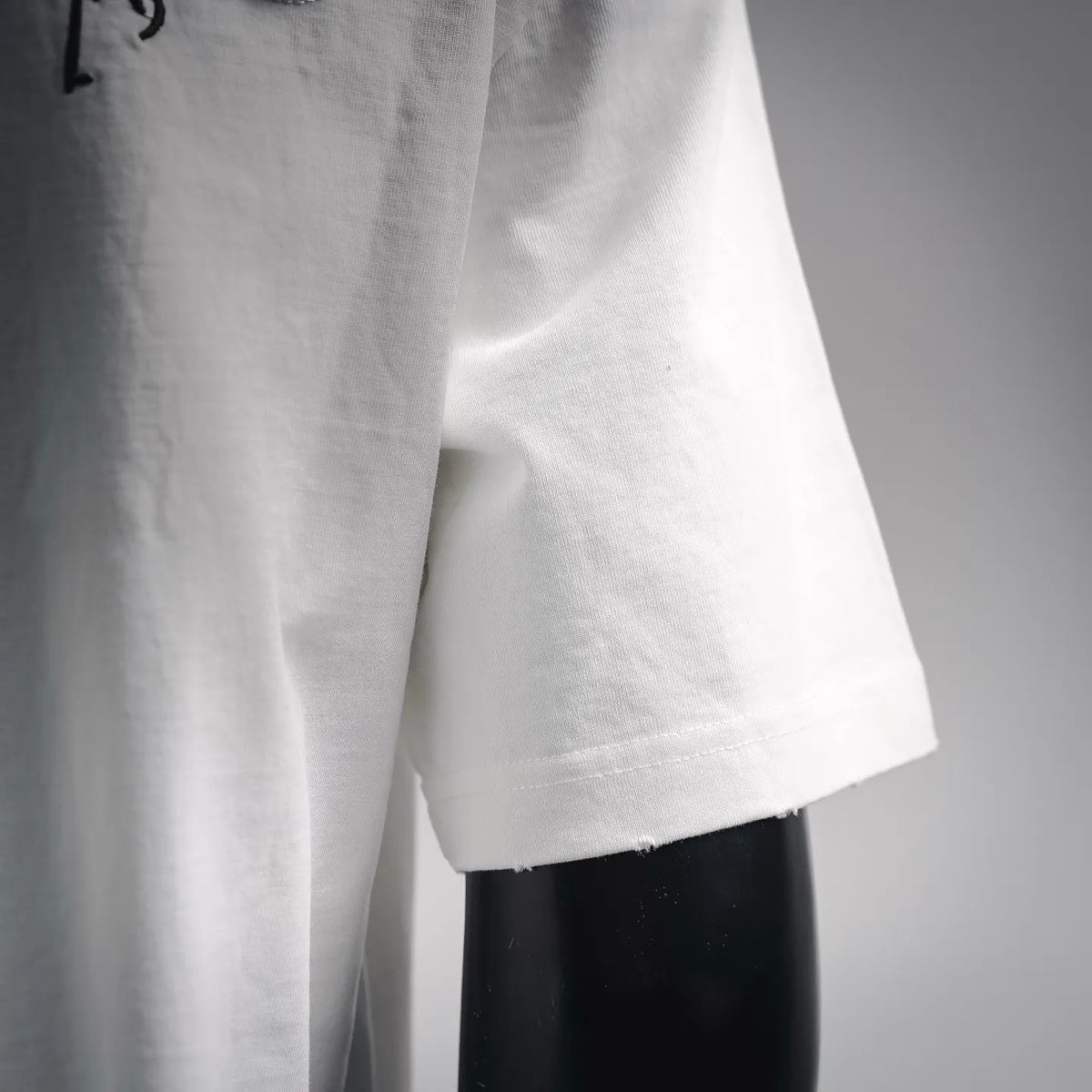White T-shirt hem and side seam detail with clean stitched edge