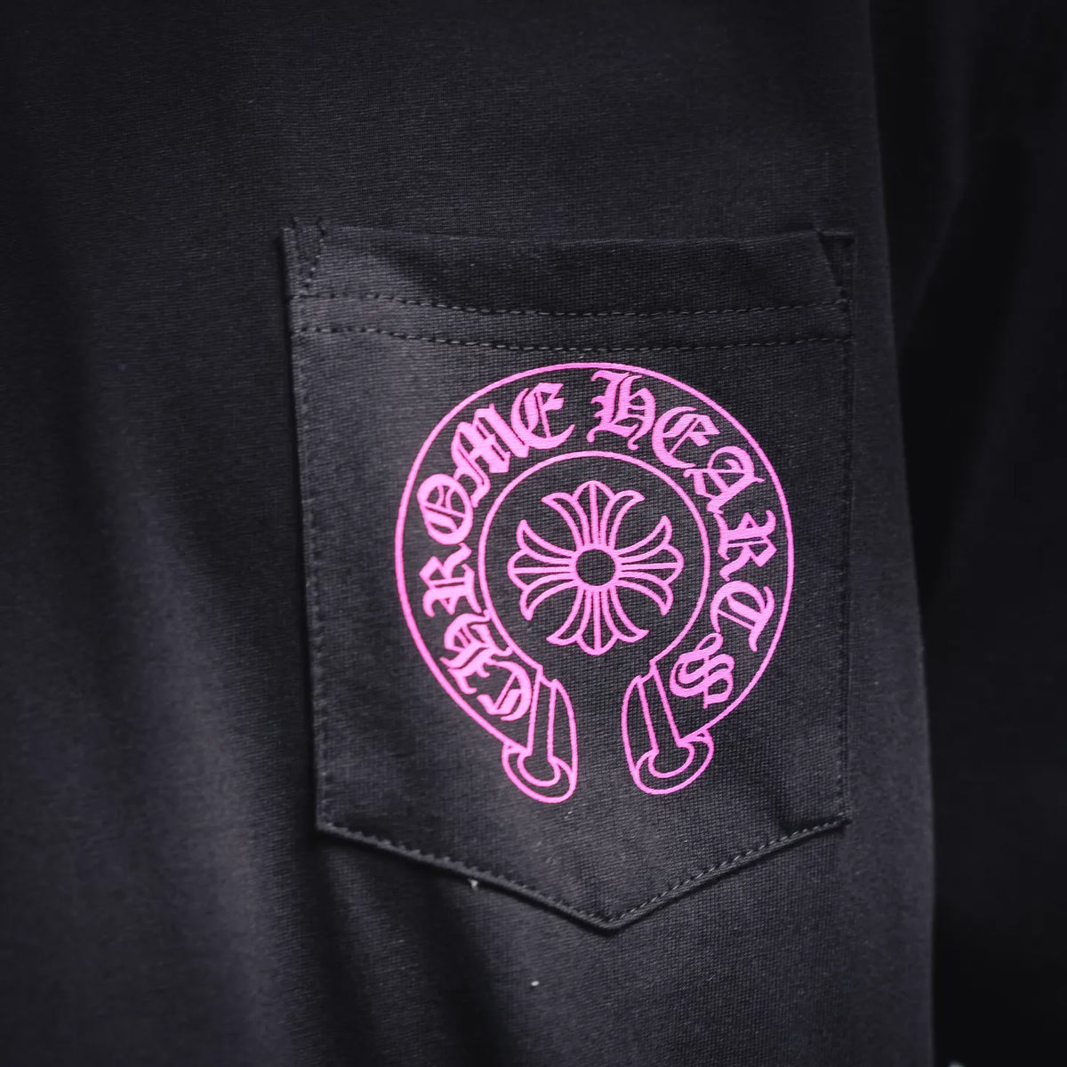 Black T-shirt chest pocket with pink logo emblem