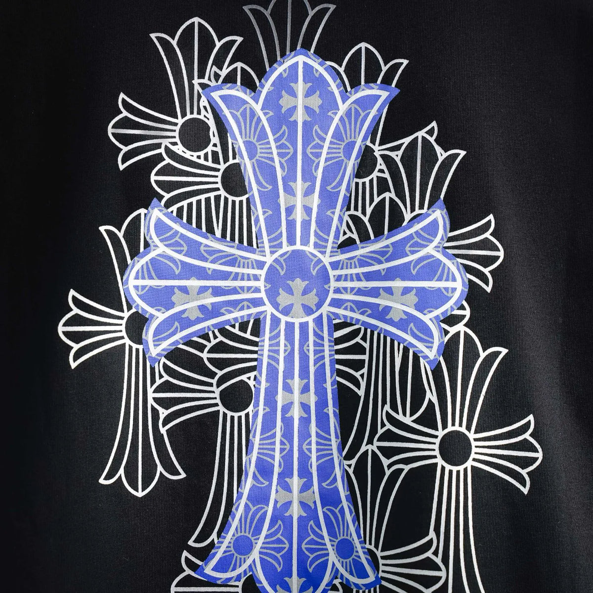 Close-up of blue-and-white cross graphic on black short-sleeve T-shirt