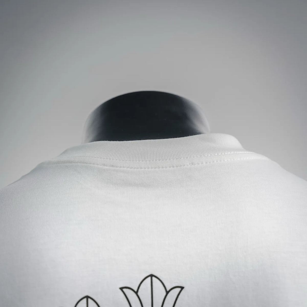 Back collar view of white T-shirt with blue cross outline detail