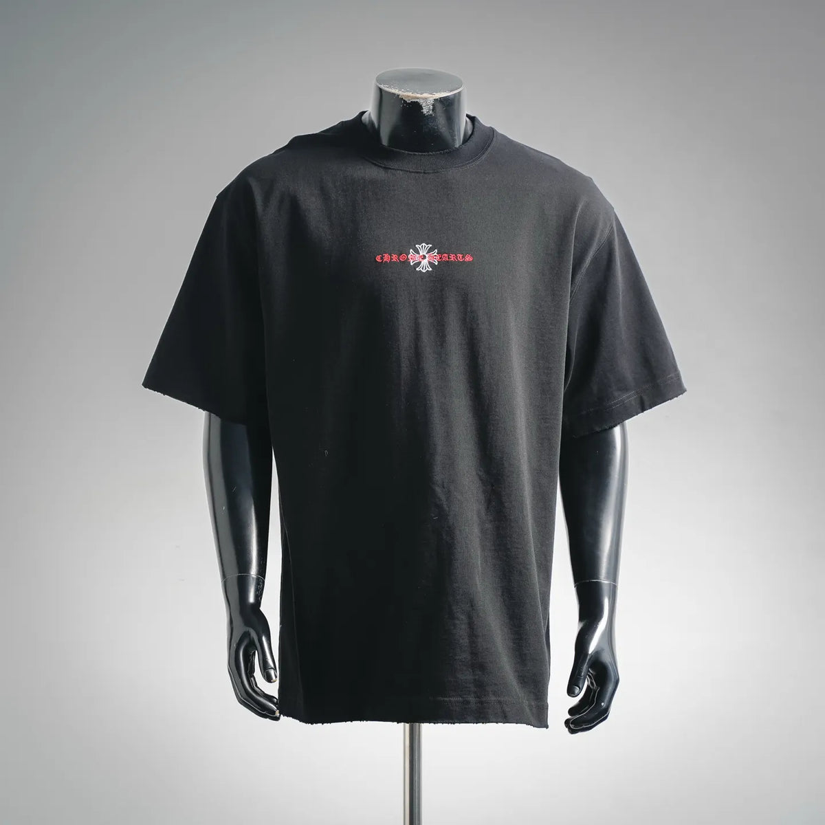 Black short-sleeve T-shirt with small chest logo graphic in red and white