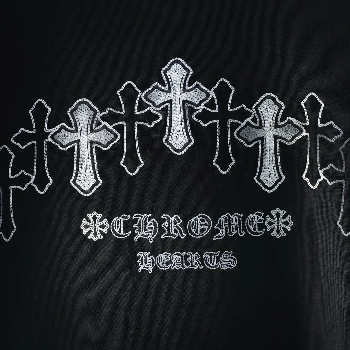 Close-up of black T-shirt back graphic with white cross shapes and text