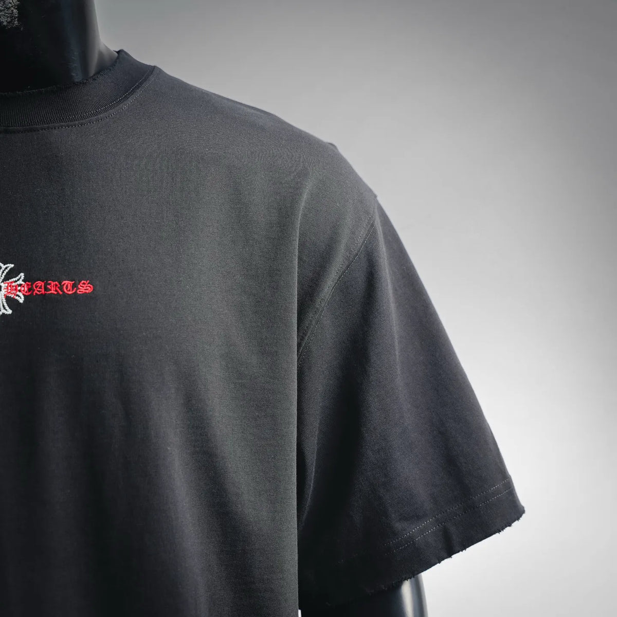 Black short-sleeve T-shirt side/back view with small red-and-white chest text