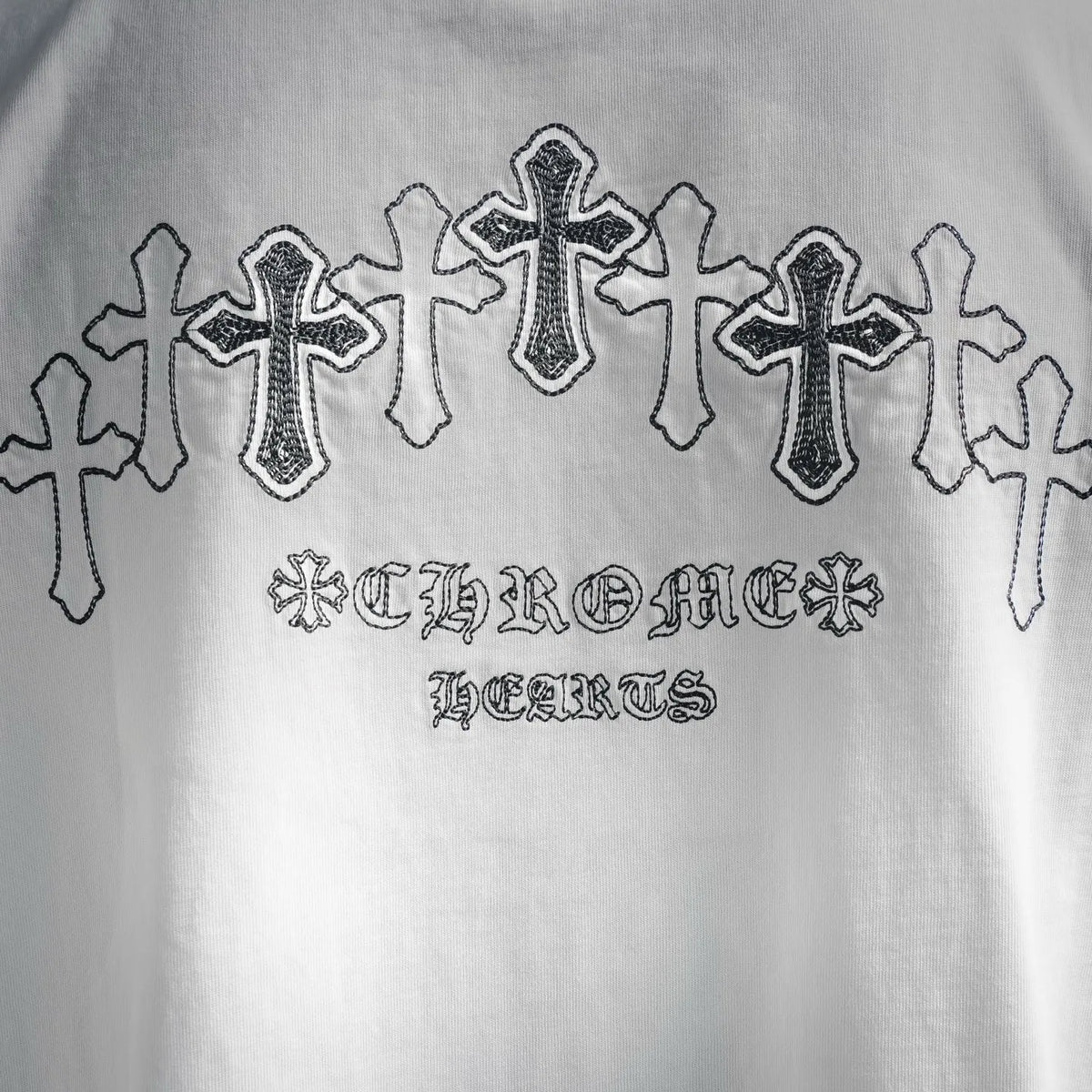 White T-shirt with embroidered cross line design and gothic text graphic