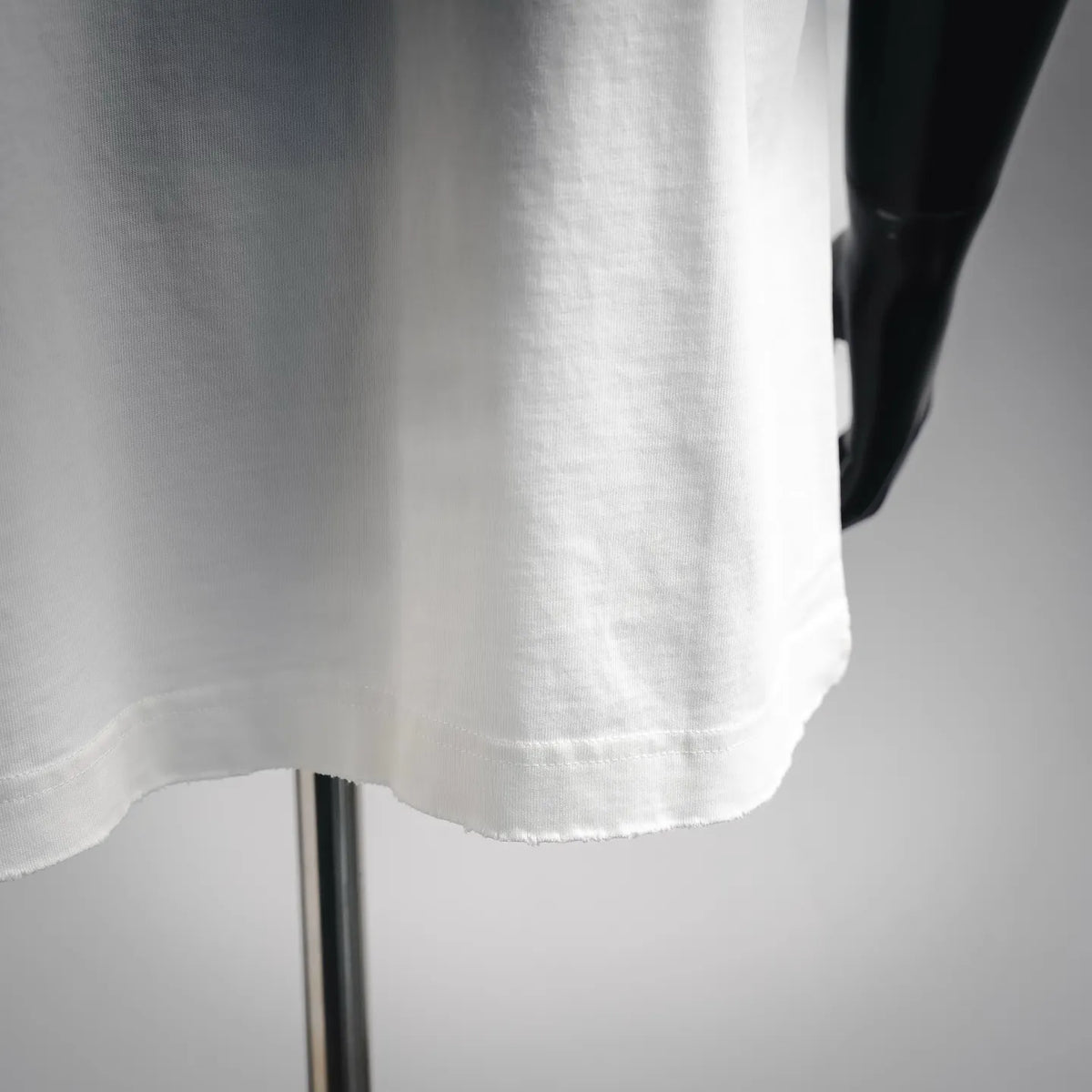 White short-sleeve T-shirt hem with visible stitching