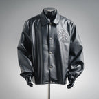 Black leather-style coat with stand collar, button front, and embroidered cross emblem