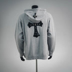 Light gray zip-up hoodie back with hood and dark cross graphic applique.