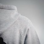 Light gray hoodie hood with drawstring cord and stitched seam detail.