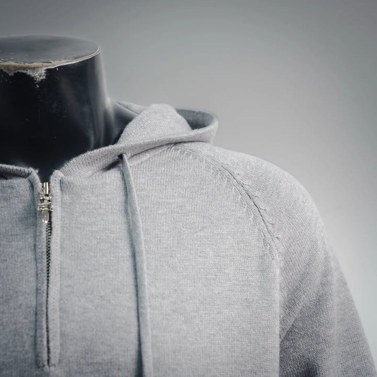 Light gray hoodie shoulder and front zipper placket detail.