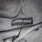 Light gray hoodie neck label with black brand tag and drawcord.