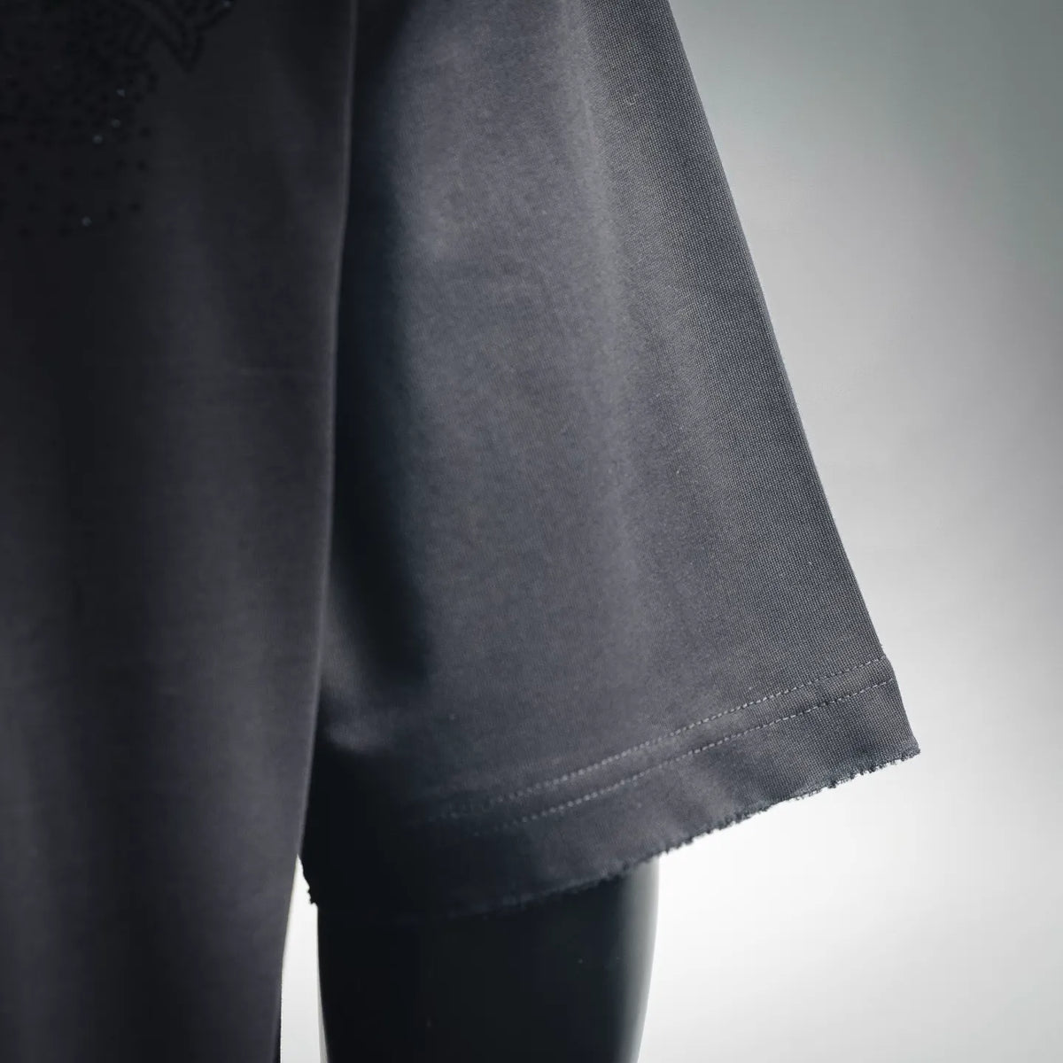 Black T-shirt sleeve hem with stitched cuff and clean bottom edge