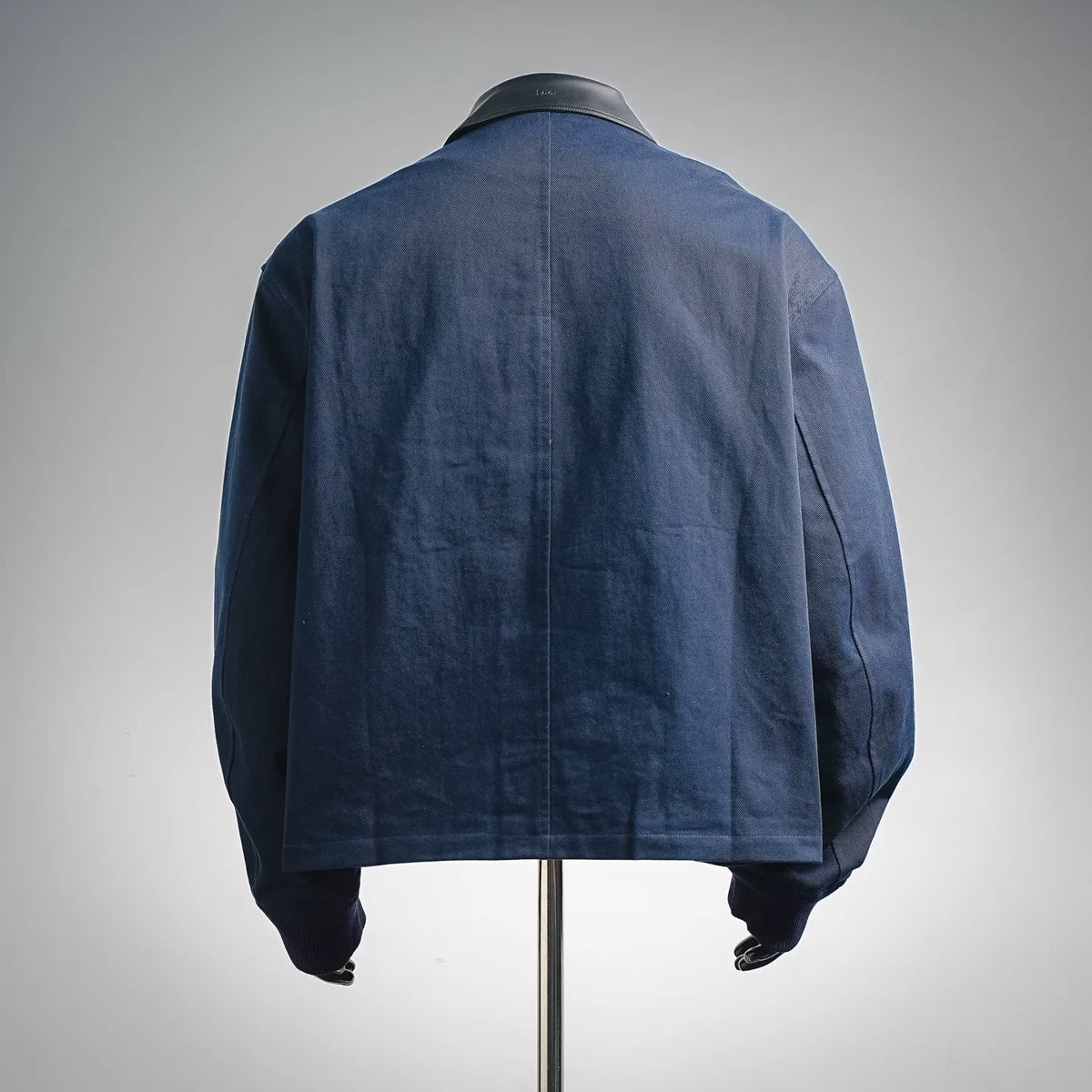 Navy denim coat back view with dark ribbed cuffs and button placket