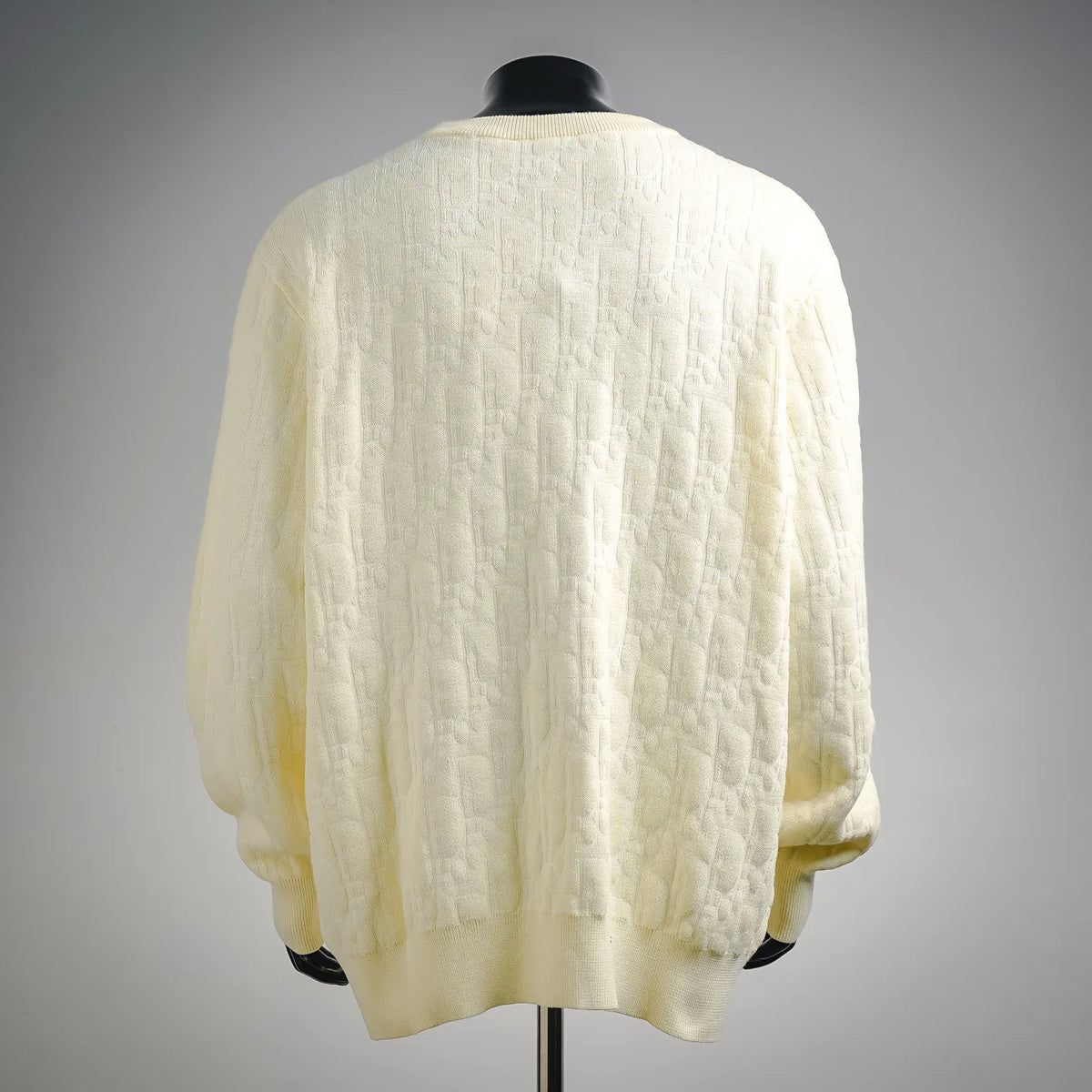 Back view of cream knit sweater with crew neck and ribbed hem
