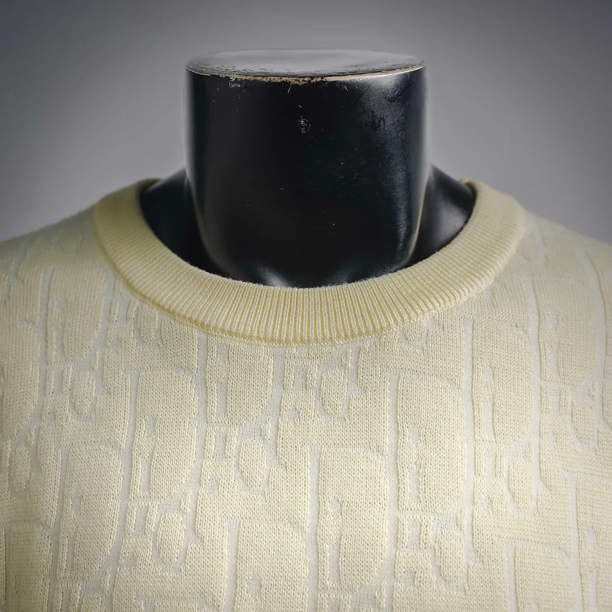 Close-up of cream knit sweater neckline with ribbed crew collar