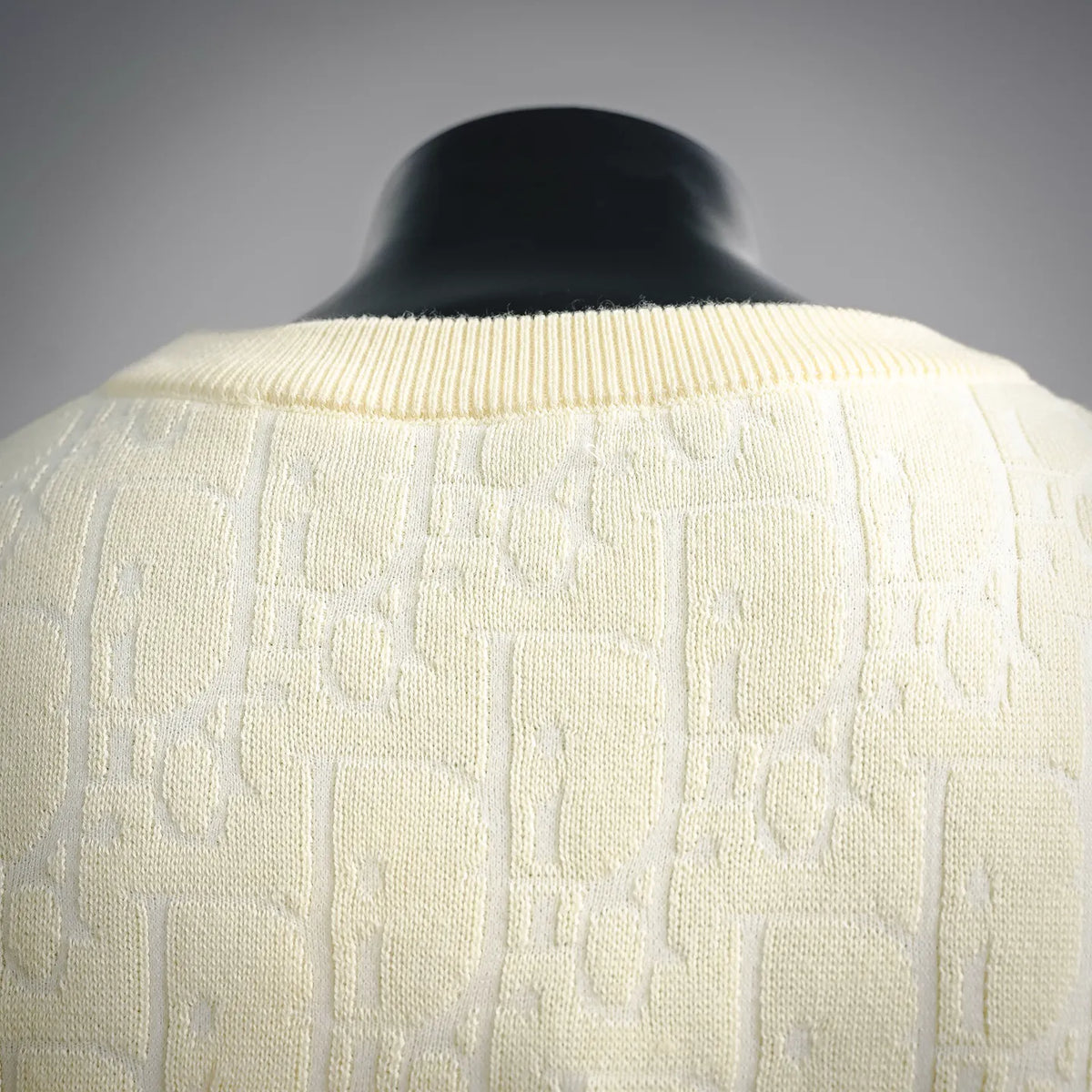 Close-up of cream knit sweater upper back with raised textured pattern