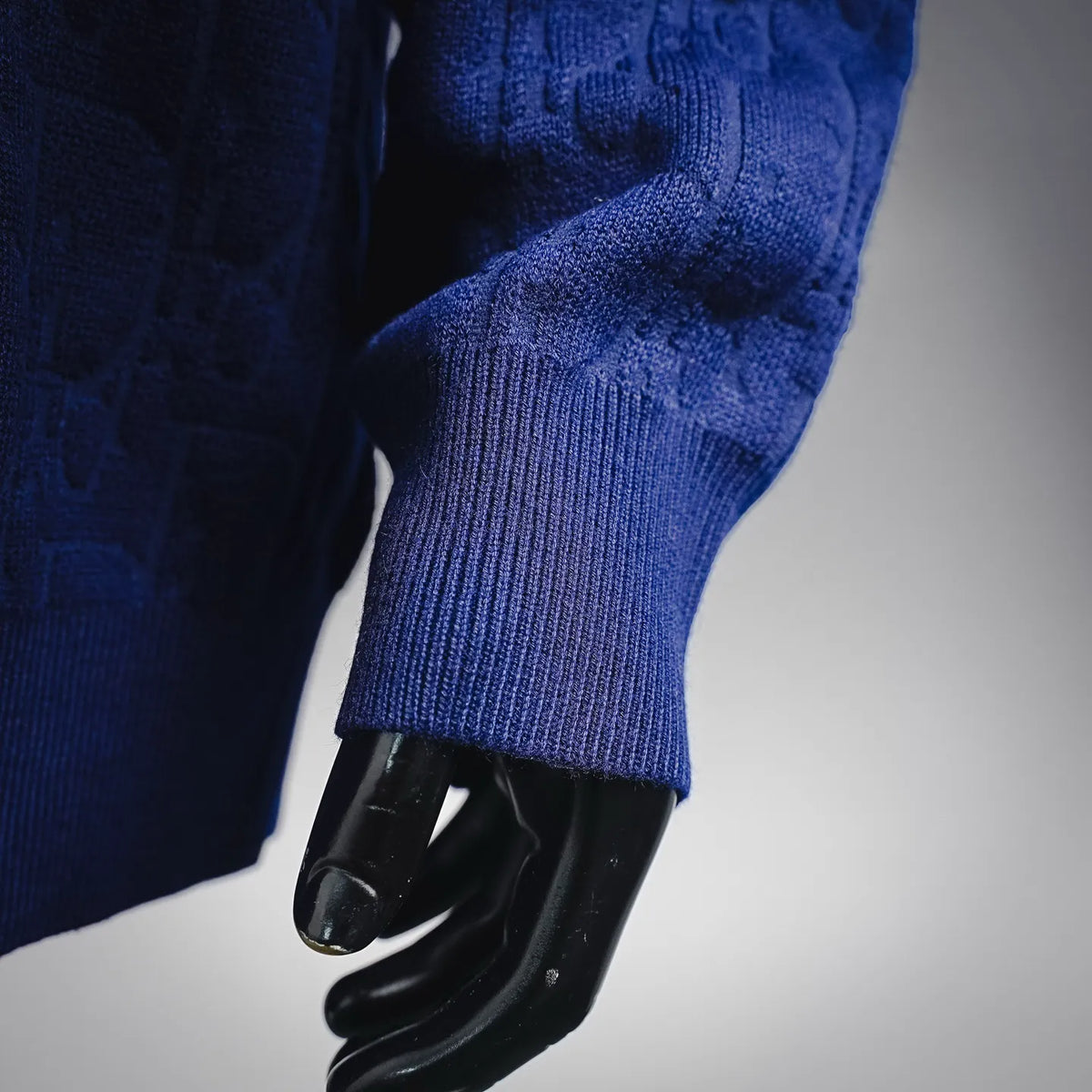 Blue knit sweater sleeve with ribbed cuff on mannequin
