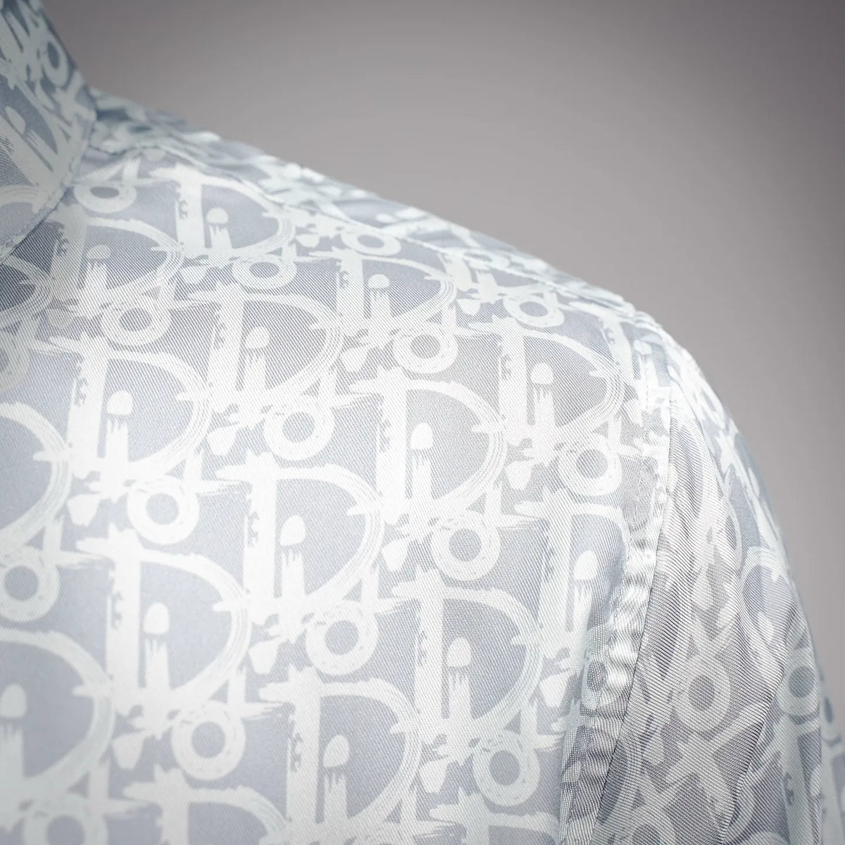 Long-sleeve side view of a light blue and white monogram button-up shirt
