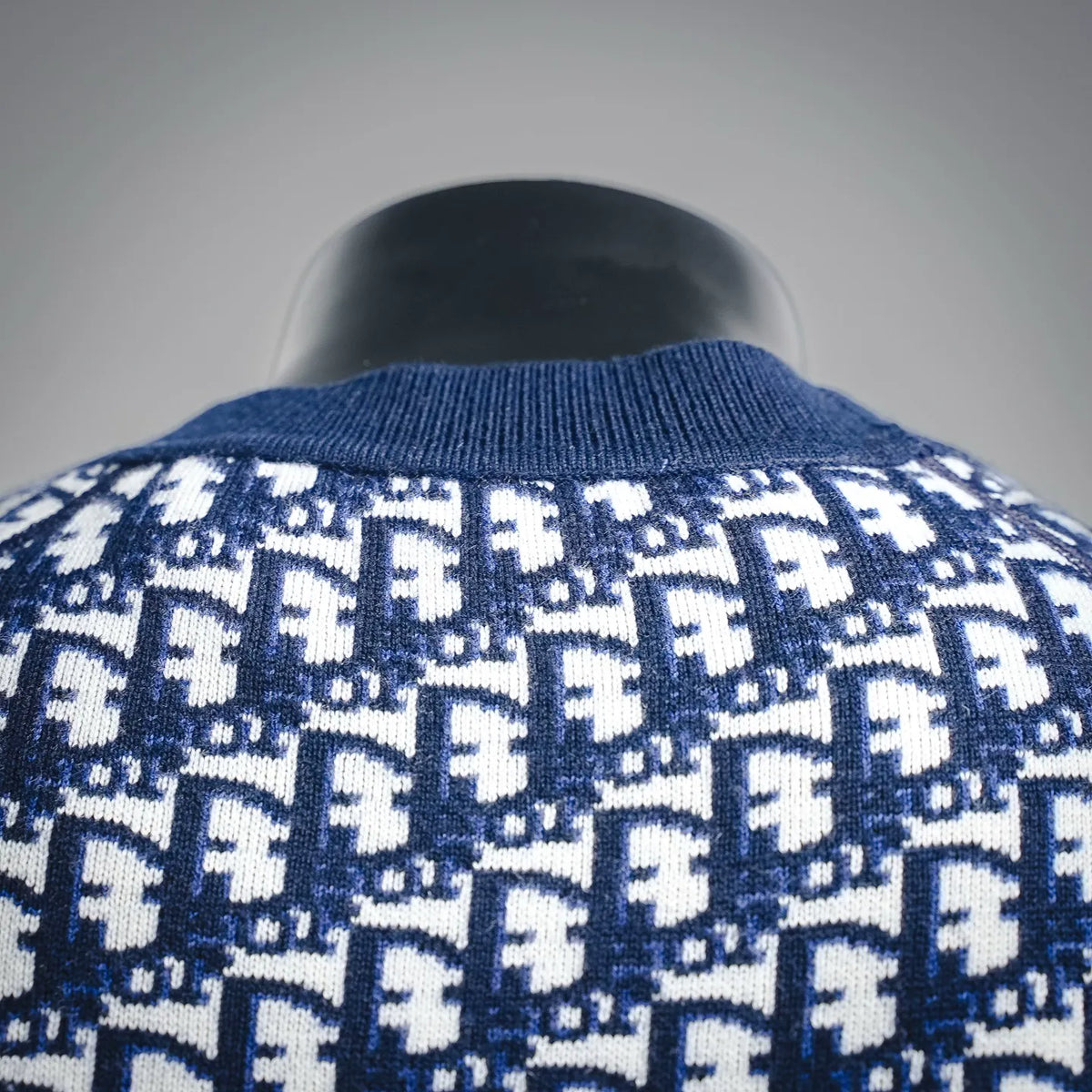 Close-up of Christian Dior monogram knit sweater neckline in blue and white pattern