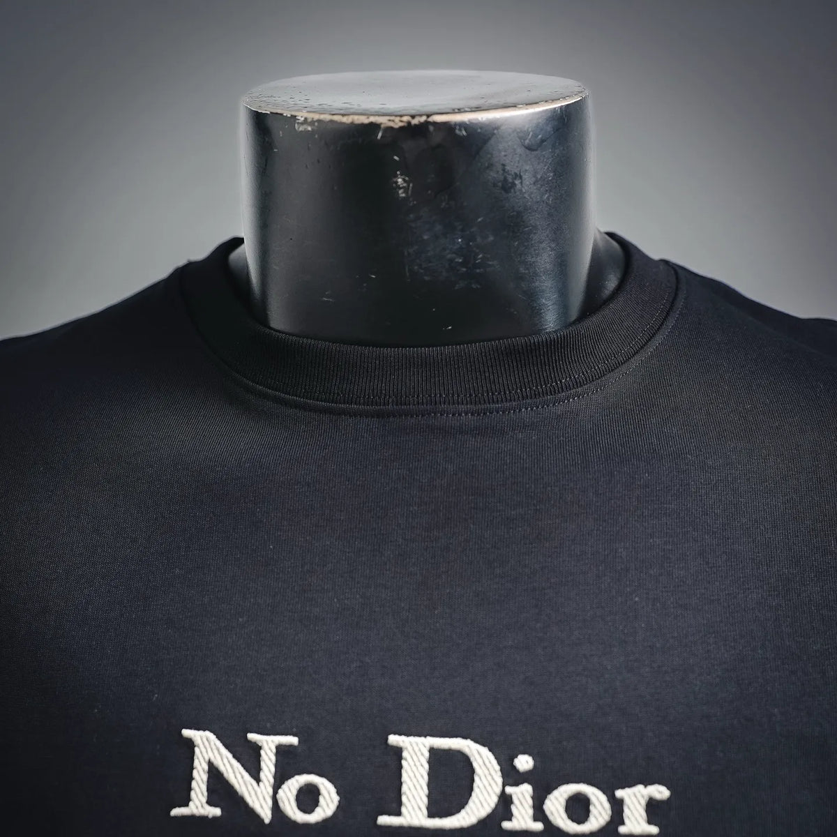 Black crewneck T-shirt neckline with “No Dior” logo text
