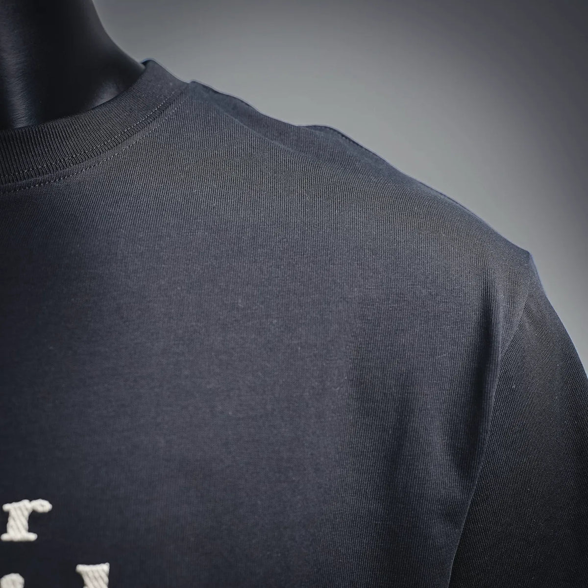 Black crewneck T-shirt side/back close-up on a mannequin