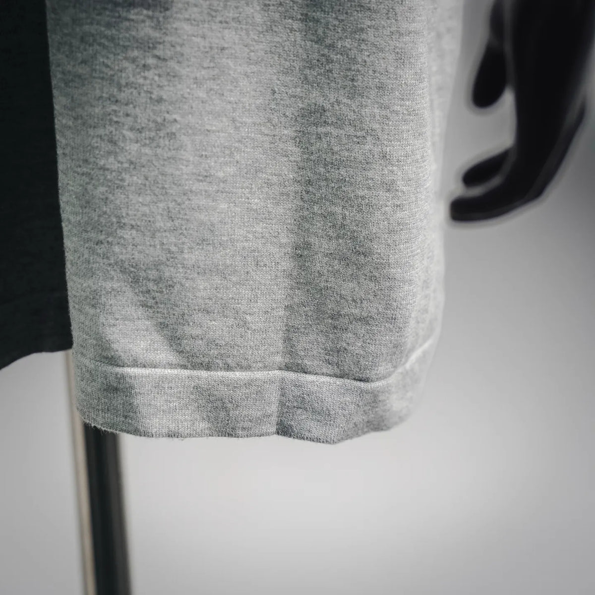 Heather gray T-shirt hem detail with double-stitching on mannequin