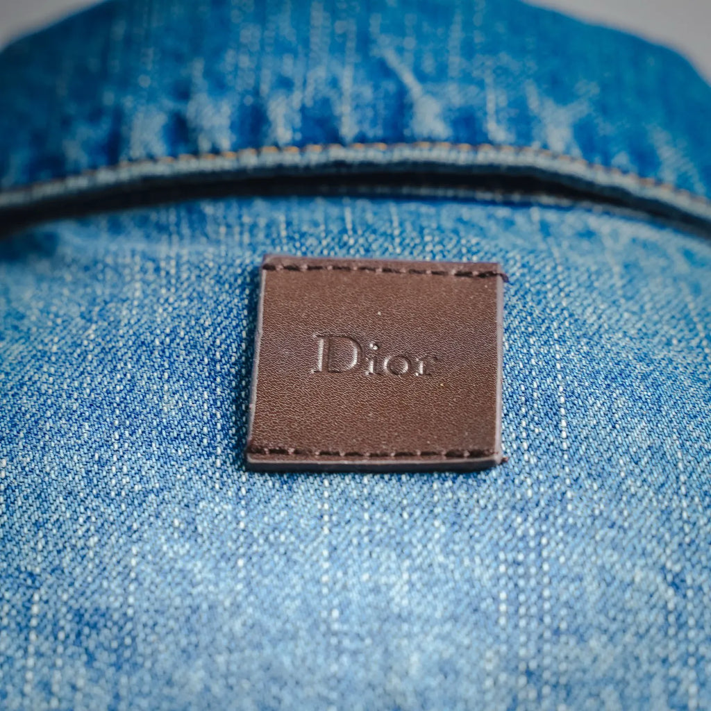 Dior leather-look brand label on light blue denim