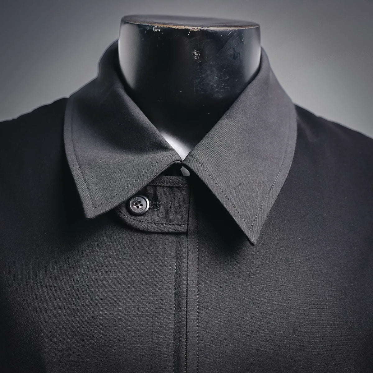 Black coat collar with snap button and textured lapel detail
