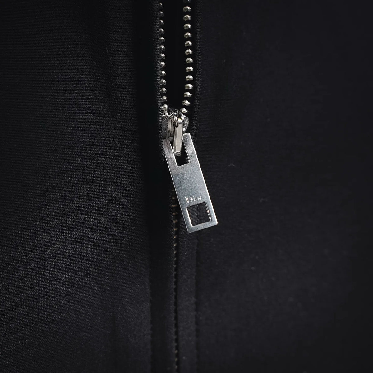 Close-up of black coat zipper with metal pull tab