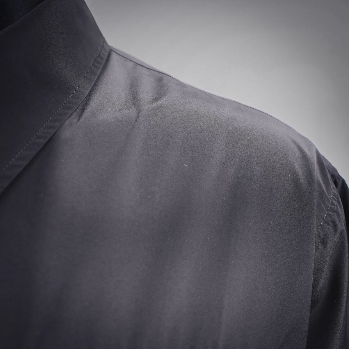 Dior dark coat sleeve and shoulder panel with subtle fabric sheen