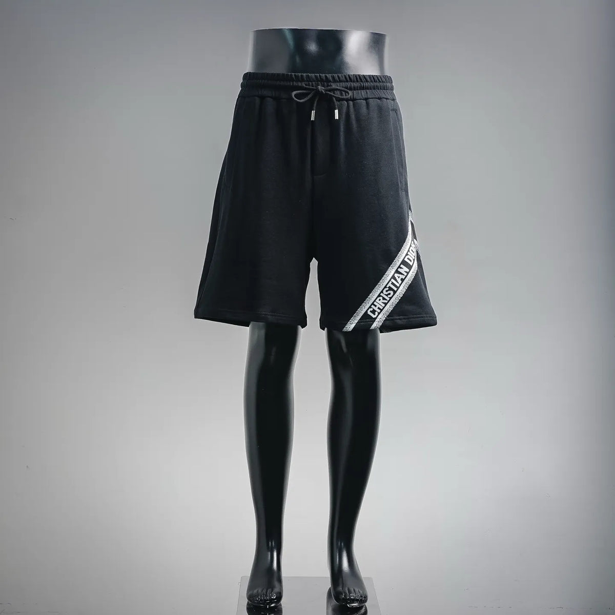 Dior black logo-trim drawstring shorts on mannequin, front view