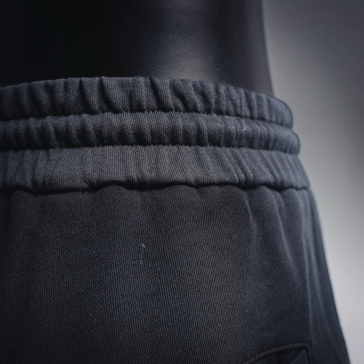 Black gathered elastic waistband of Dior shorts, close-up detail