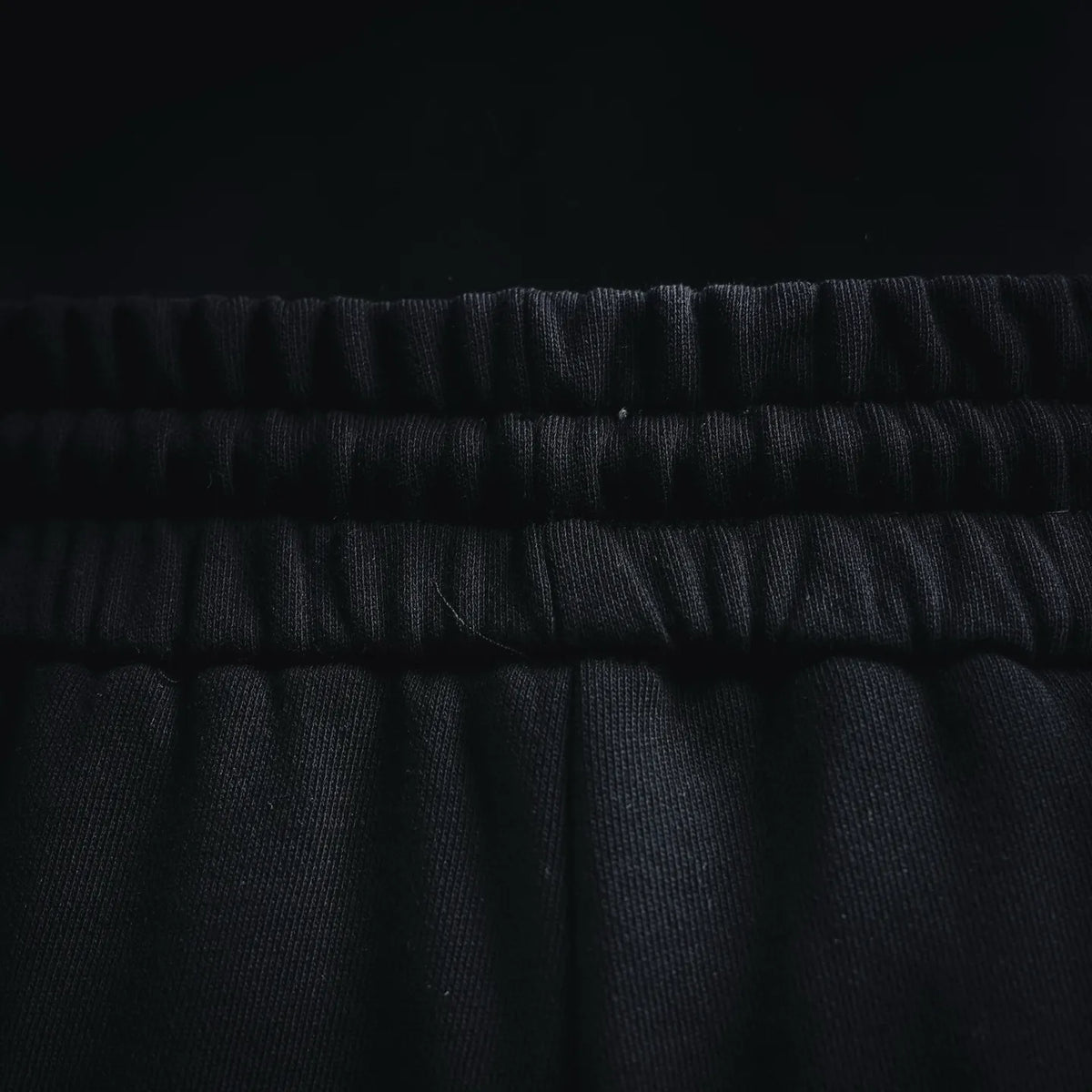 Black elastic waistband with gathered texture, shorts close-up