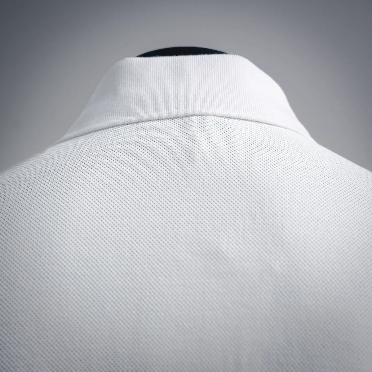 White polo shirt collar and upper back fabric texture close-up