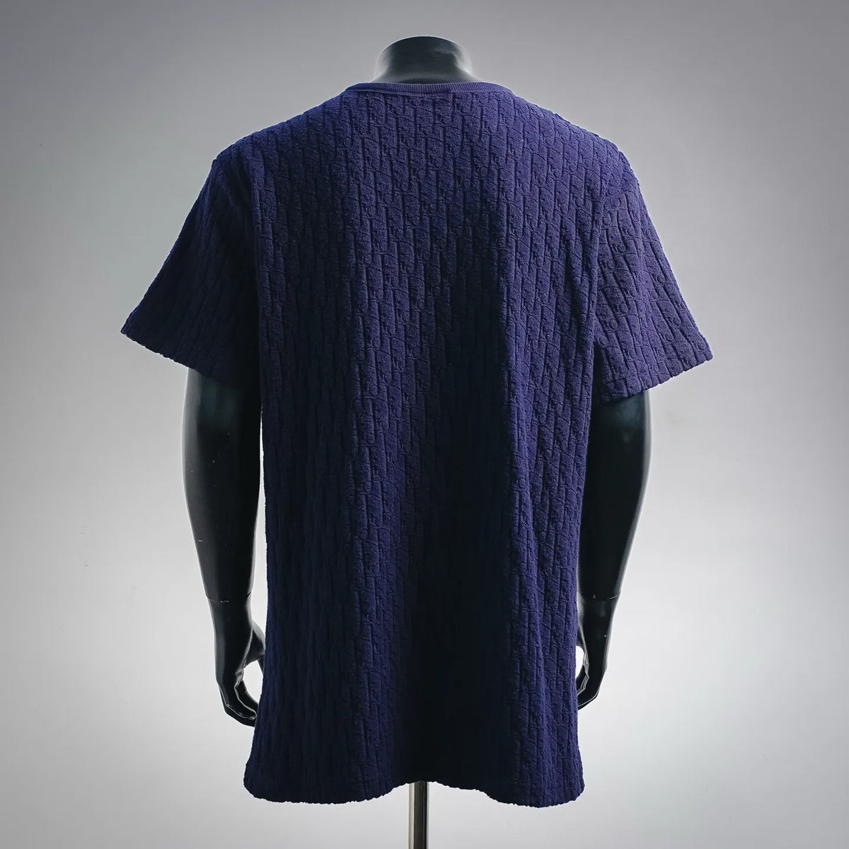 Dark blue short-sleeve knit shirt, textured allover pattern, back view