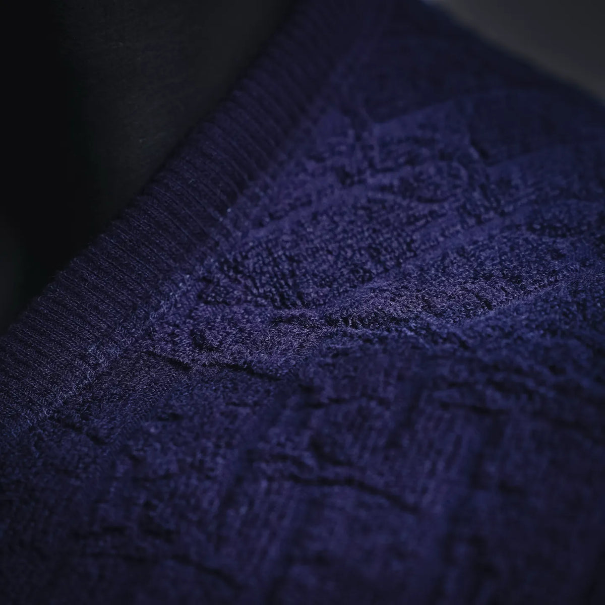Dark blue knit fabric close-up with visible texture and stitching