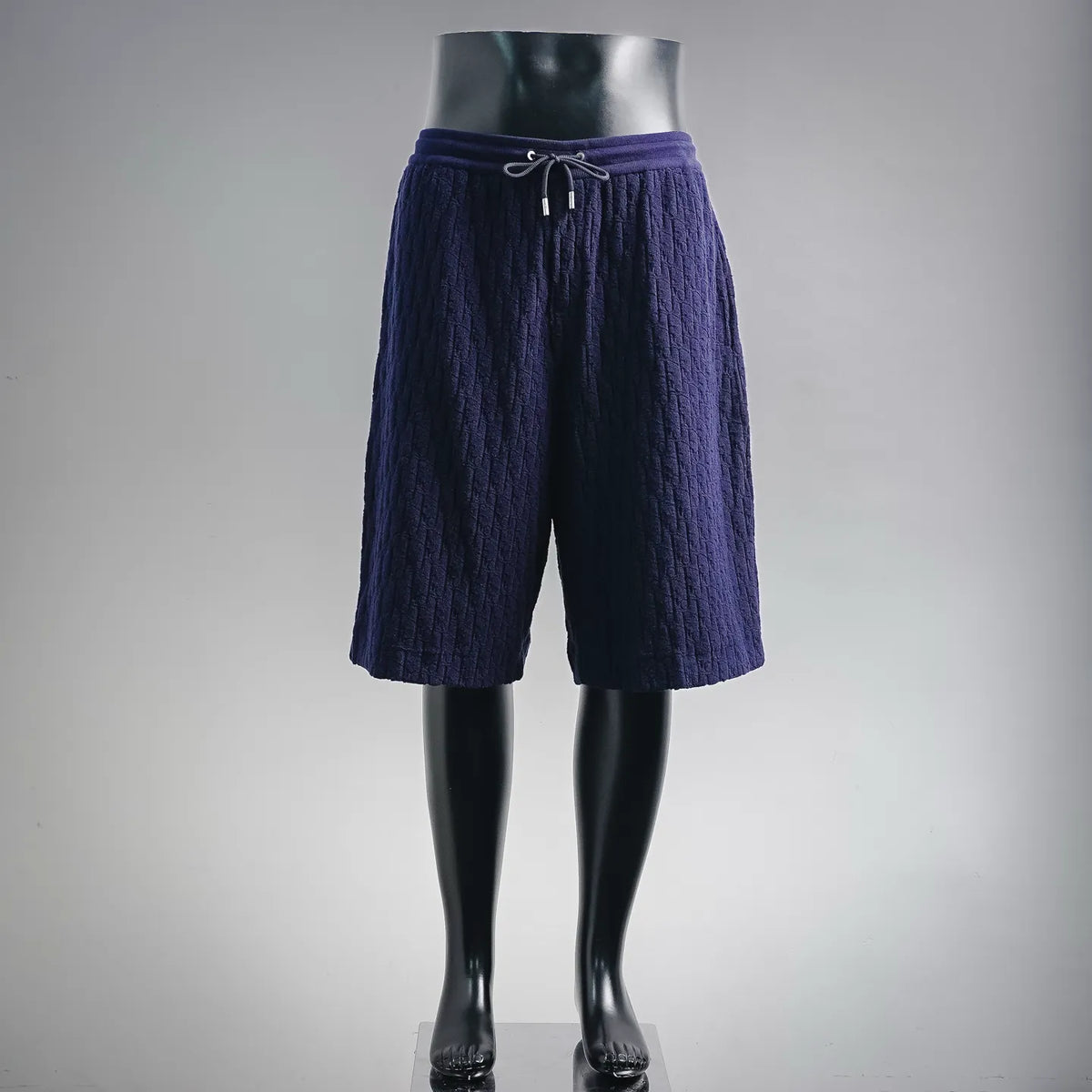 Navy textured drawstring shorts with elastic waistband and pleated front