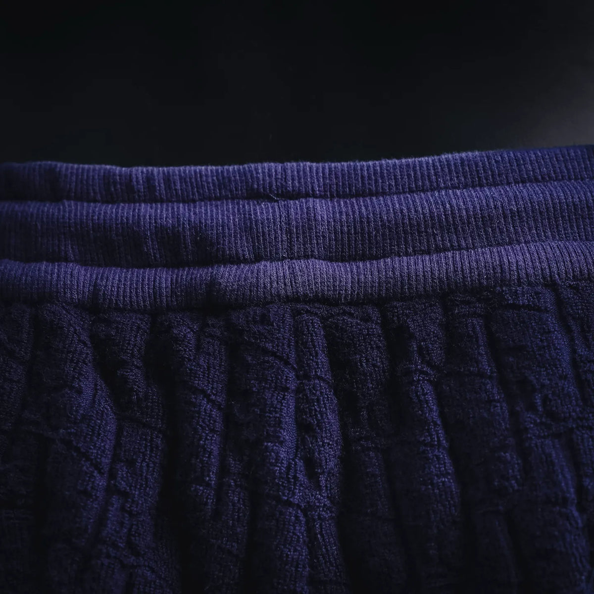 Close-up of navy waistband and textured vertical stitch pattern on shorts