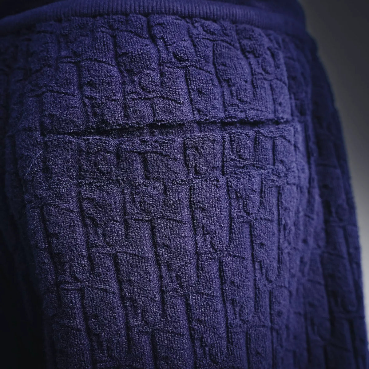 Close-up of dark blue textured fabric with raised block pattern