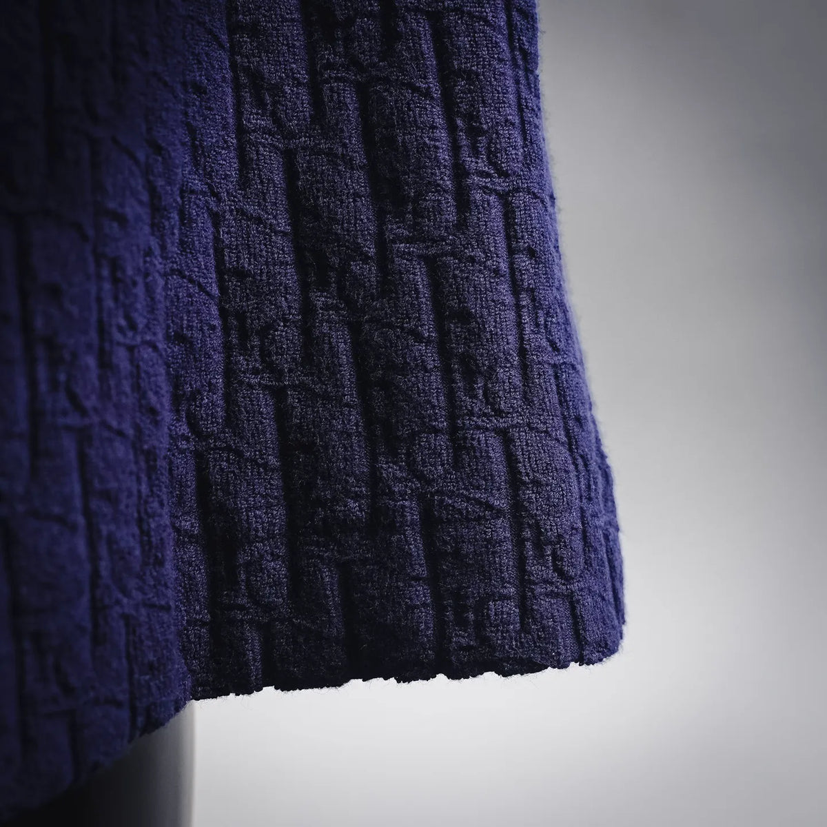 Side view of dark blue textured shorts hem with gathered ruffle