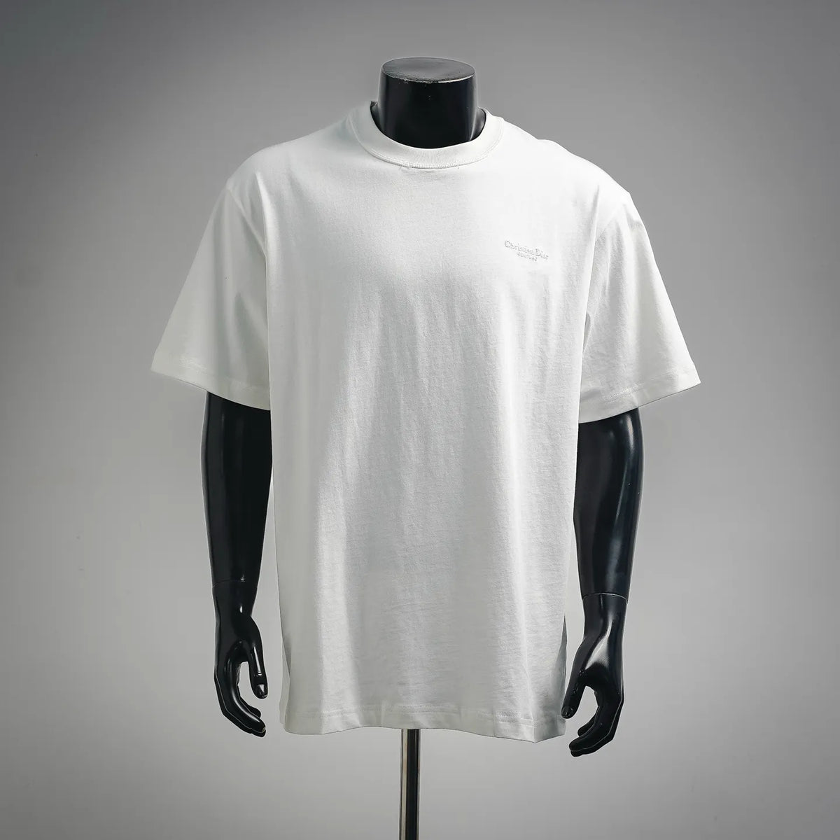 White short-sleeve crewneck T-shirt on a mannequin, small chest Dior logo
