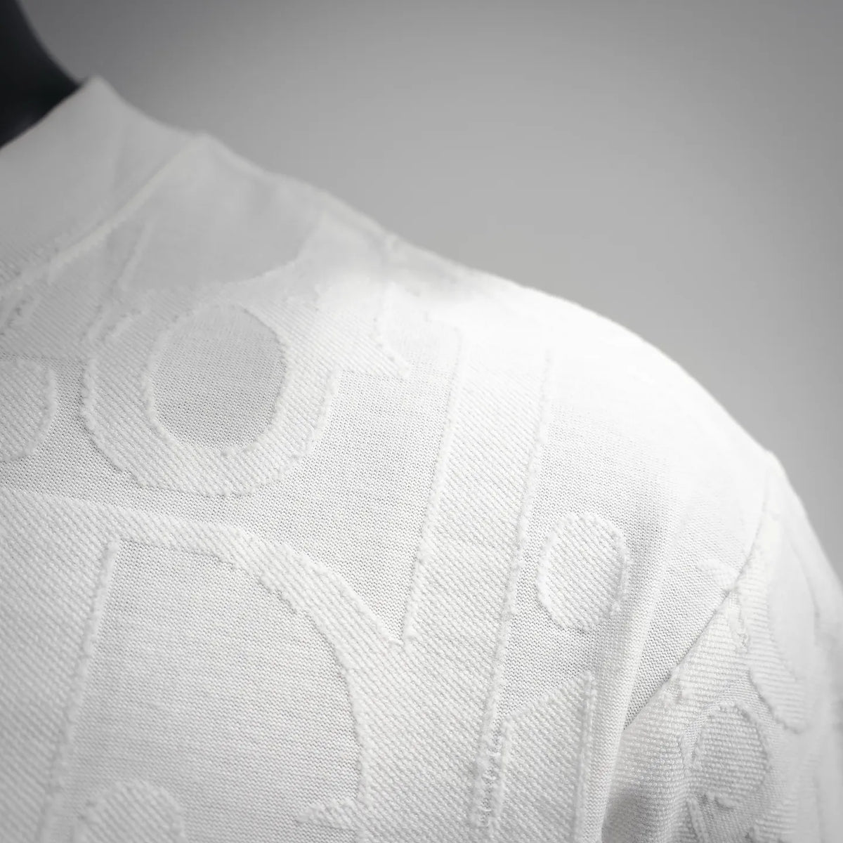 White Dior crewneck T-shirt close-up of raised logo pattern on neckline and shoulder