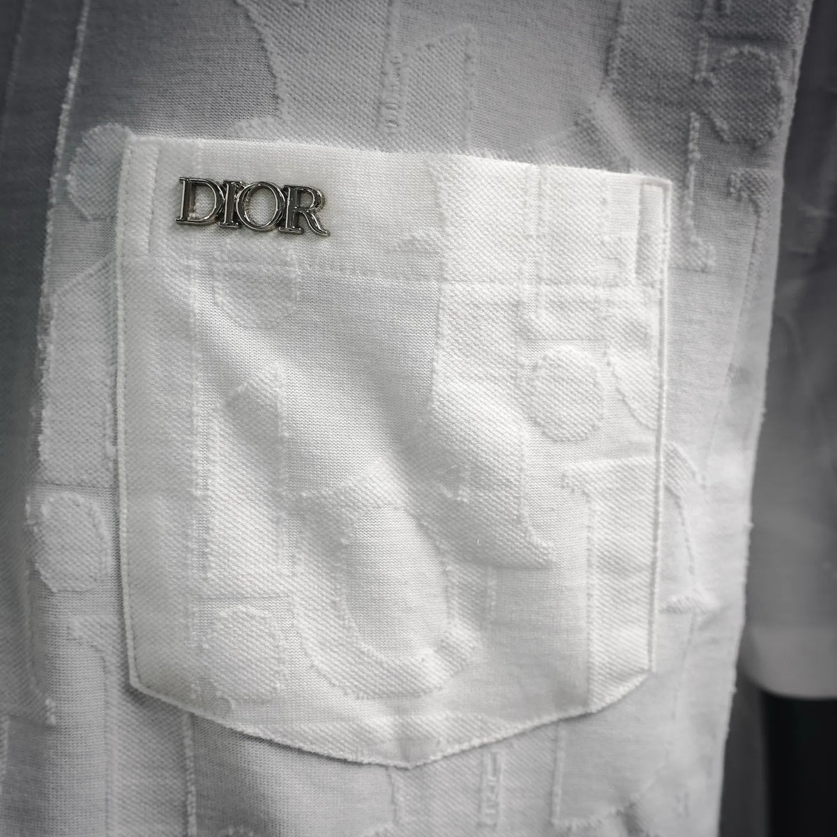 White Dior T-shirt chest pocket close-up with Dior logo label