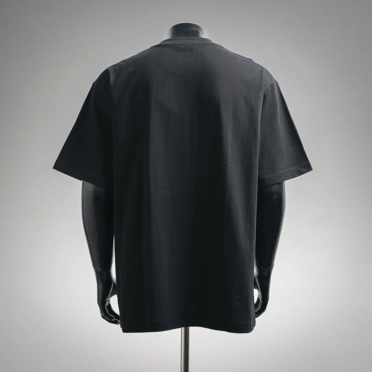 Black crewneck T-shirt with short sleeves, plain back view on mannequin